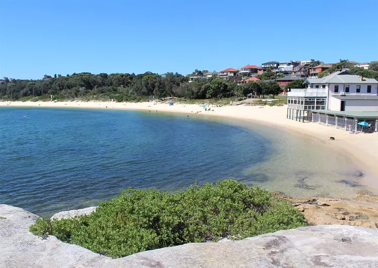 Looking down on bright white La Perouse Beach on a sunny day in Sydney.