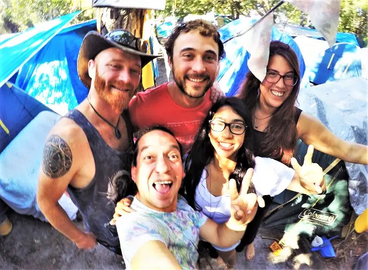 A group of backpackers smiling at a camping ground in Byron Bay, Australia.