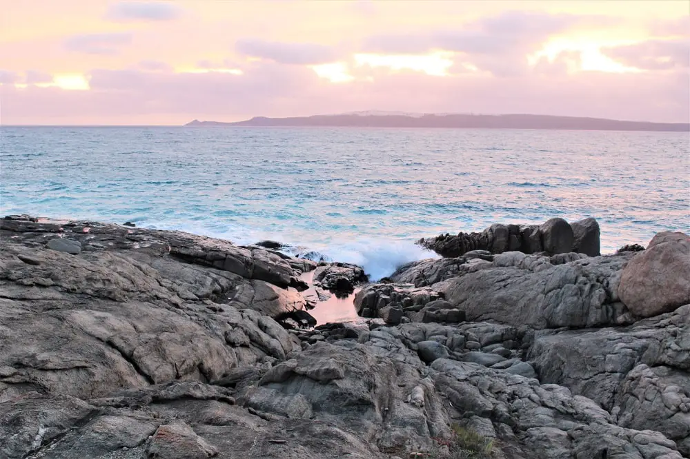 A pastel pink sunset over the ocean at Bremer Bay, Western Australia.