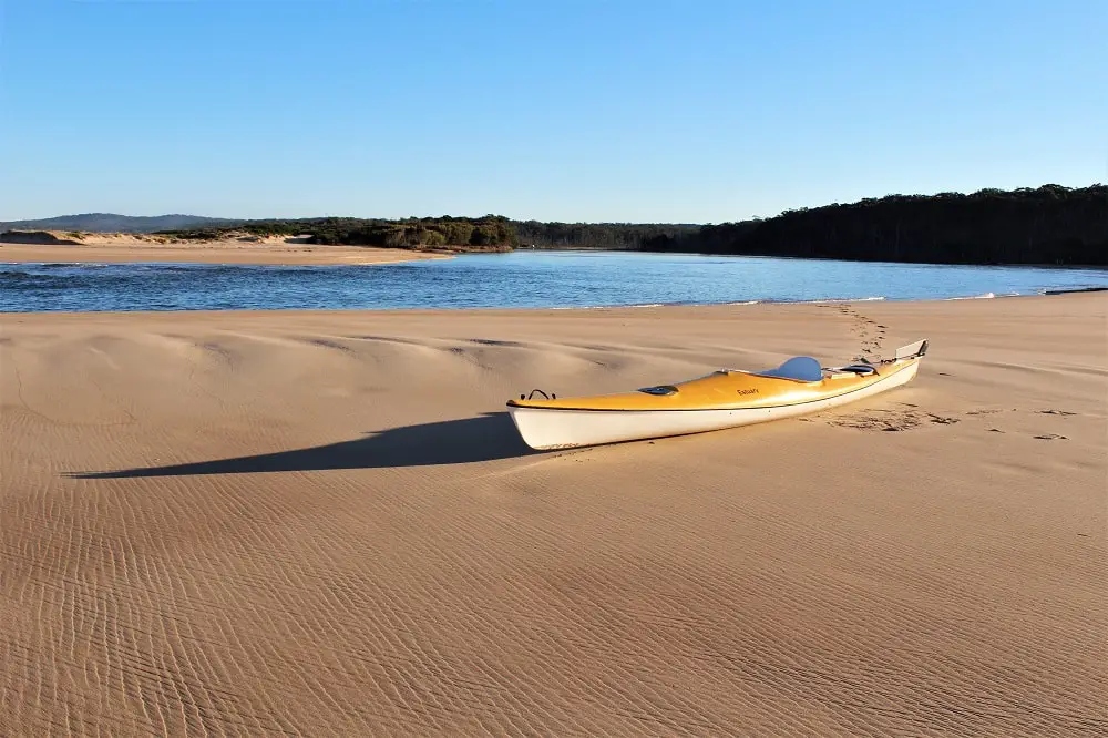 A yellow kayak on streaky wet sand at North Durras Beach, Murramarang National Park.