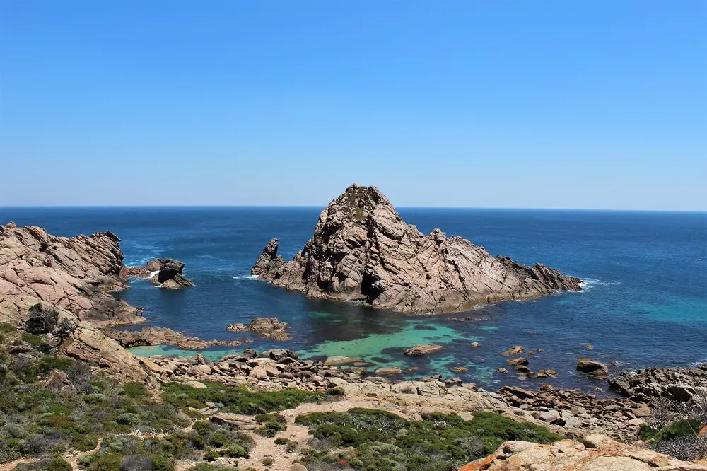 Sugarloaf Rock sticking out of the ocean in Dunsborough, WA. This is a great photo stop on your Perth to Adelaide road trip.