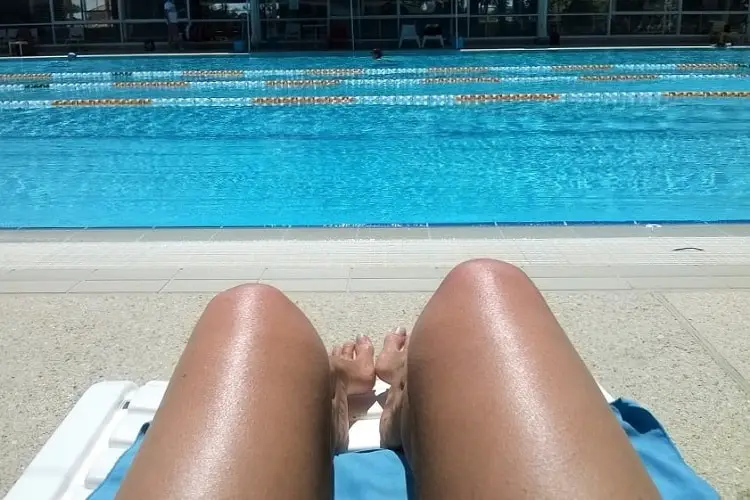 Woman on a sun lounger at Beatty Park swimming pool in perth.