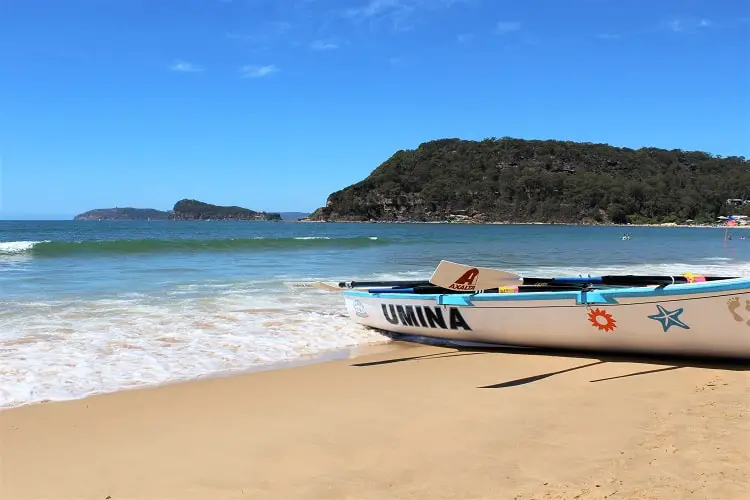 Umina Beach in NSW with a canoe on the sand.