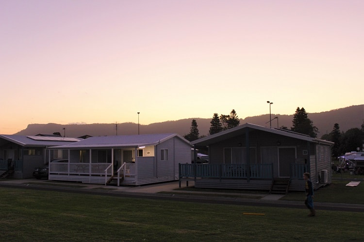 Cabins at Bulli Beach Tourist Park in Wollongong with a beautiful pink sky at sunset.