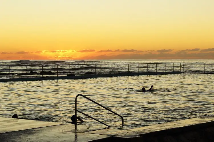 Early morning swimmers at Bulli Rock Pool at sunrise.