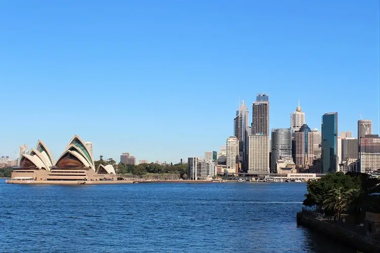 Looking across the harbour at Sydney Opera House and CBD skyscrapers.