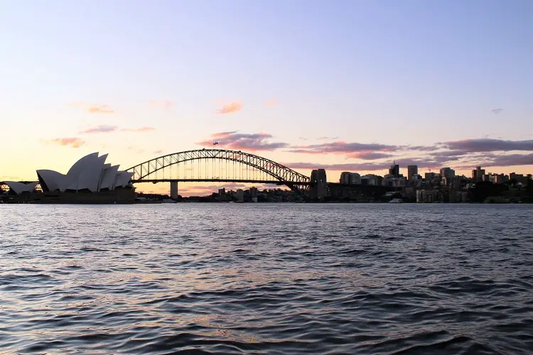 Pink sunset and Sydney Opera House and Harbour Bridge seen from Mrs Maquarie's Chair lookout.