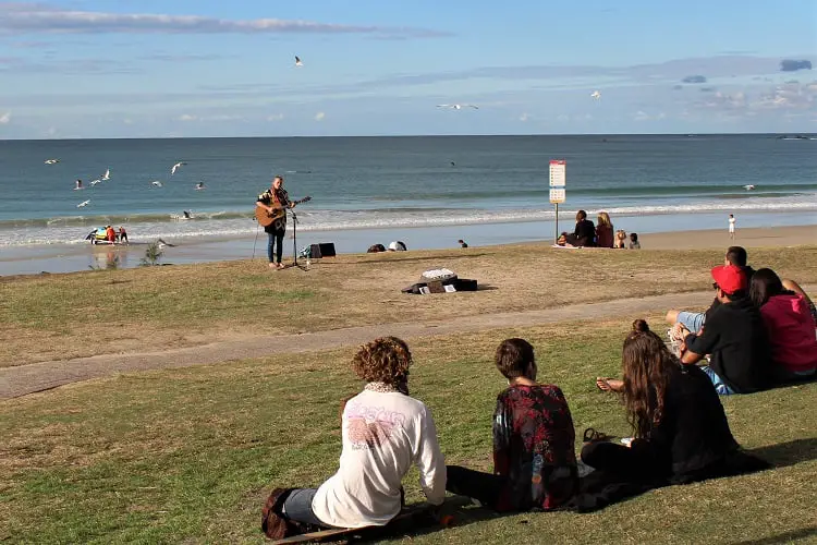 Watching a busker at Main Beach in Byron Bay.