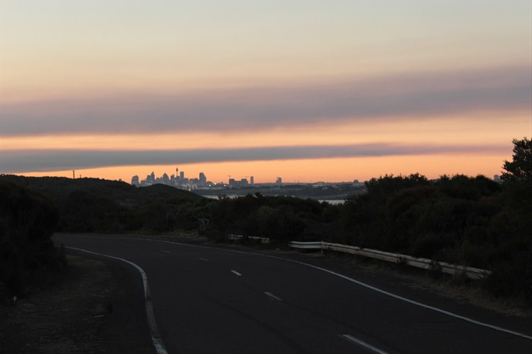 View of Sydney CBD skyline at sunset from Cape Solander Drive in Kurnell NSW.