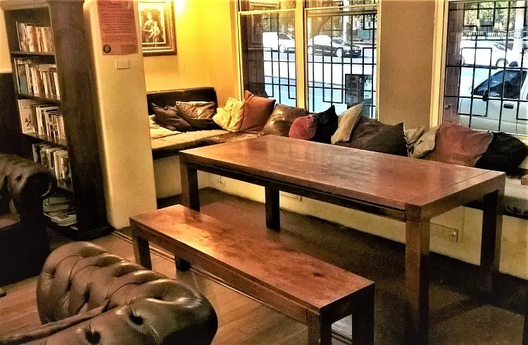 Communal area with bookshelves and leather sofas at The Nunnery hostel, Melbourne.