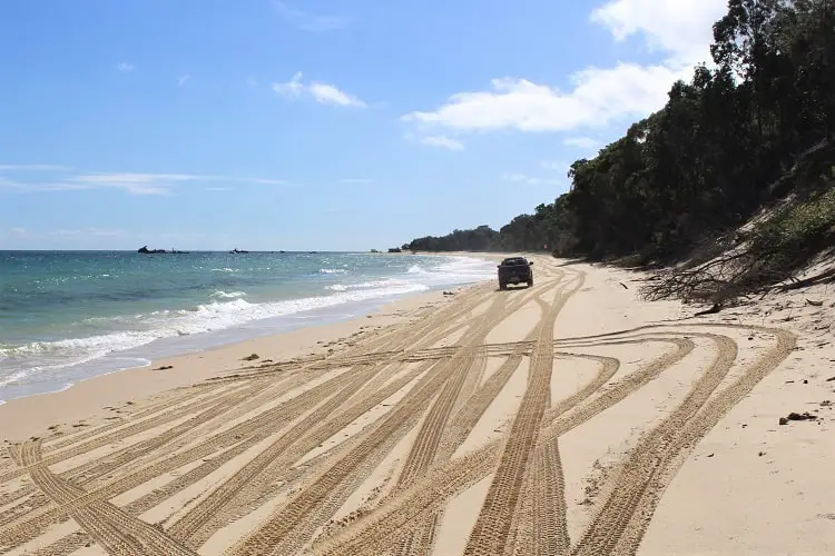 A 4WD driving across the beach at Tangalooma.
