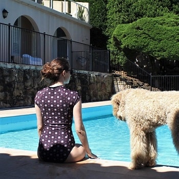 Professional house sitter and blogger Lisa Bull sitting by a swimming pool in Sydney, Australia.