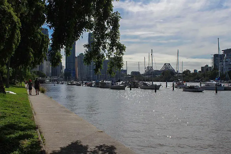 A couple walking along the river in Brisbane on a sunny day.