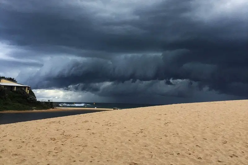 Very dark, swirling rain clouds over Curl Curl Beach in Sydney.