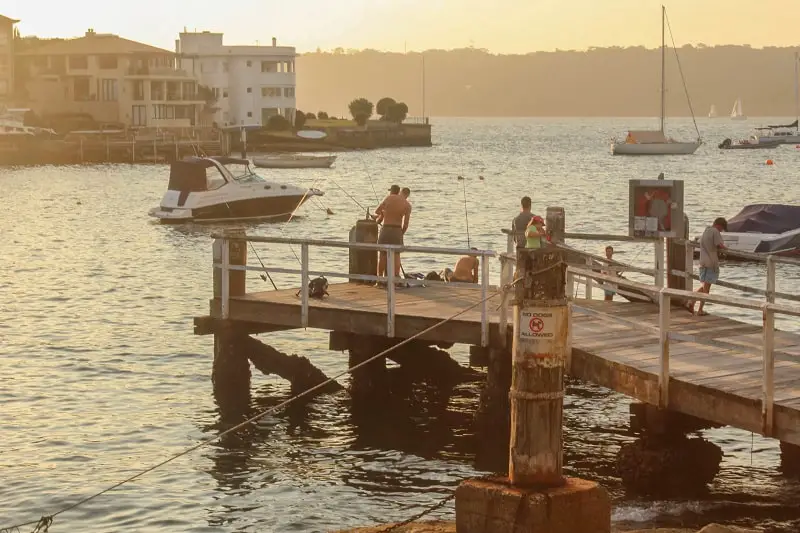 Locals fishing at sunset at Parsley Bay Reserve in Vaucluse, Sydney.