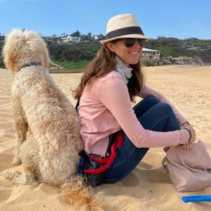 British expat in Australia blogger, Lisa Bull, on a dog beach in Australia with a groodle.