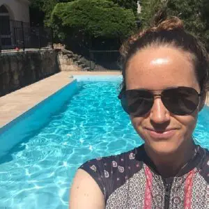 Blogger Lisa Bull by a swimming pool on a luxury house sit in Australia.